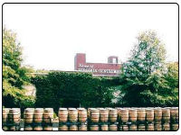 A photo looking over the whisky barrels toward the A. Smith Bowman Virginia